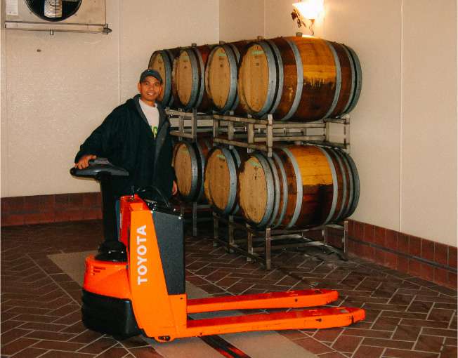 Old photo of Leo Gabica, with a hand truck and barrels in the background.